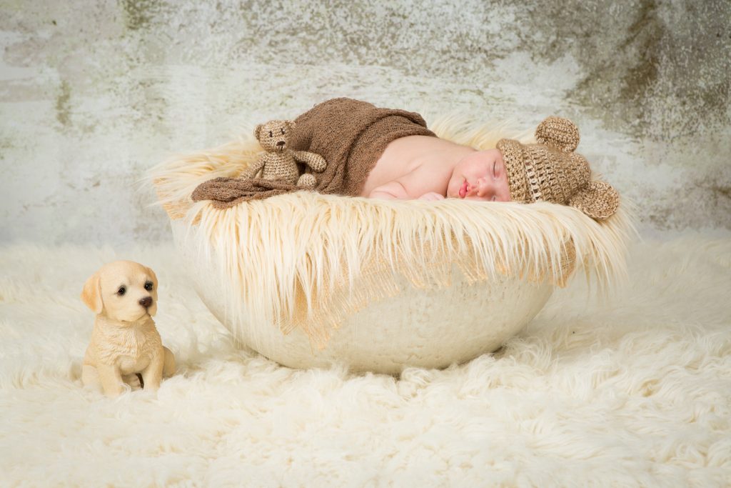 Newborn shoot Jolie op witte schaal met kleedje en met een mutsje op en een beertje erbij