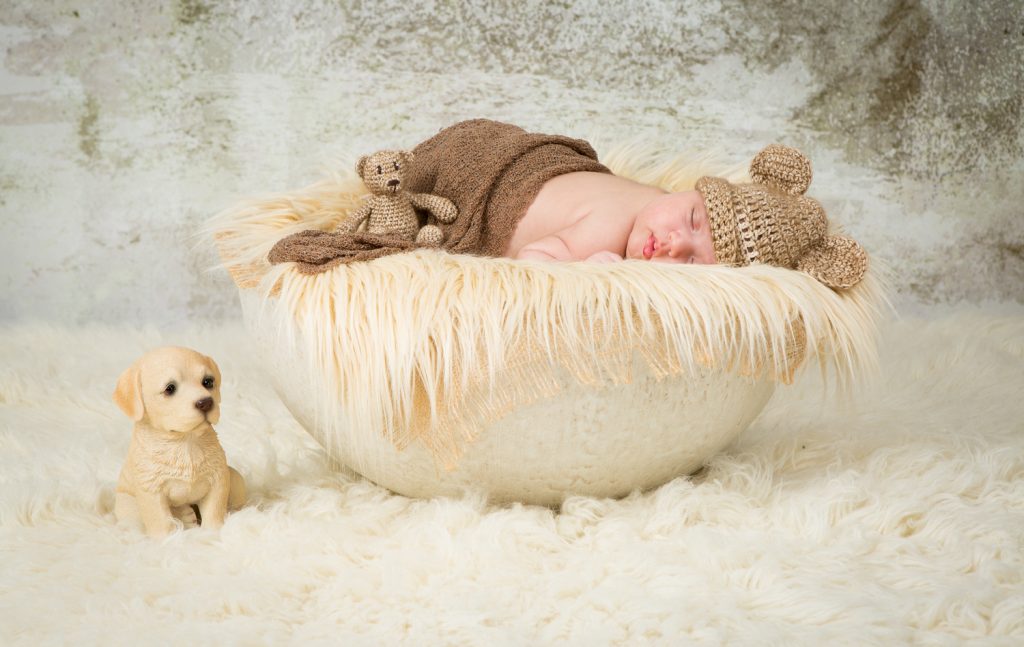 Newborn shoot Jolie op witte schaal met kleedje en met een mutsje op en een beertje erbij