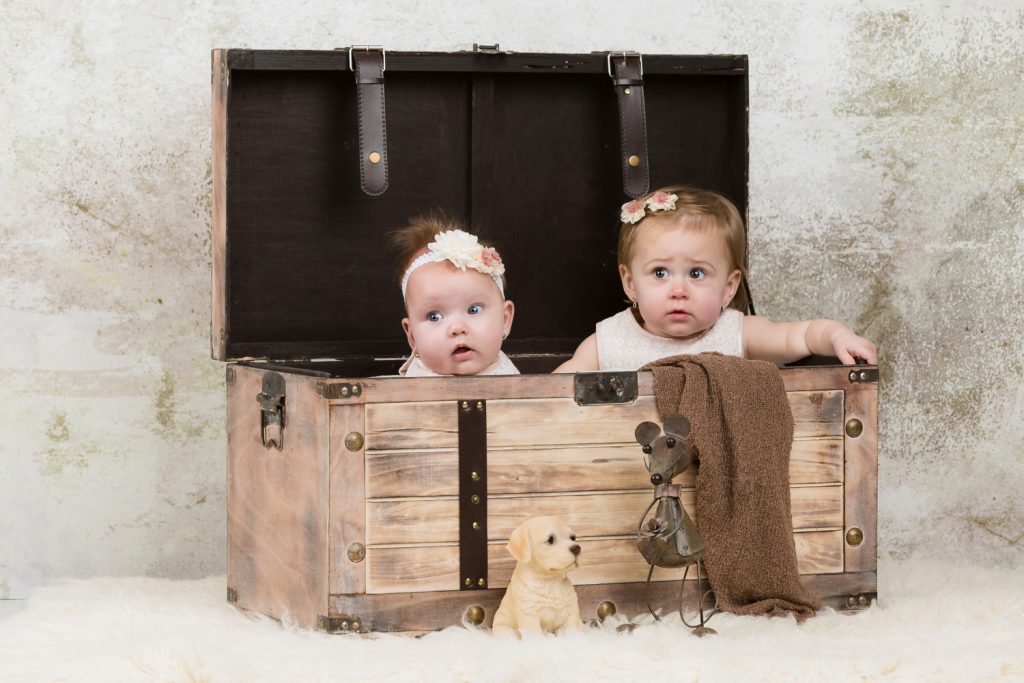 Baby fotoshoot Chelsea en Gianna met witte kleiding aan en als prop een kist