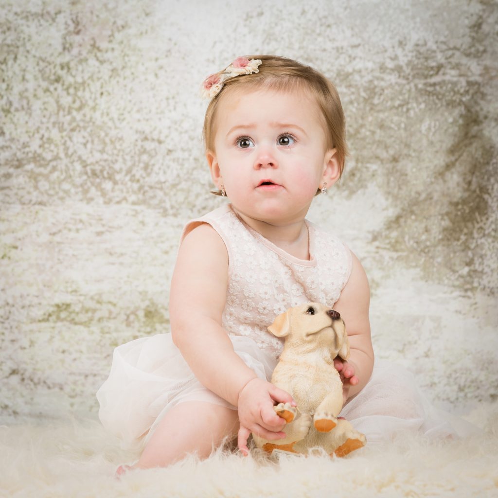 Baby fotoshoot Gianna met witte kleding aan en een hondje in haar handen