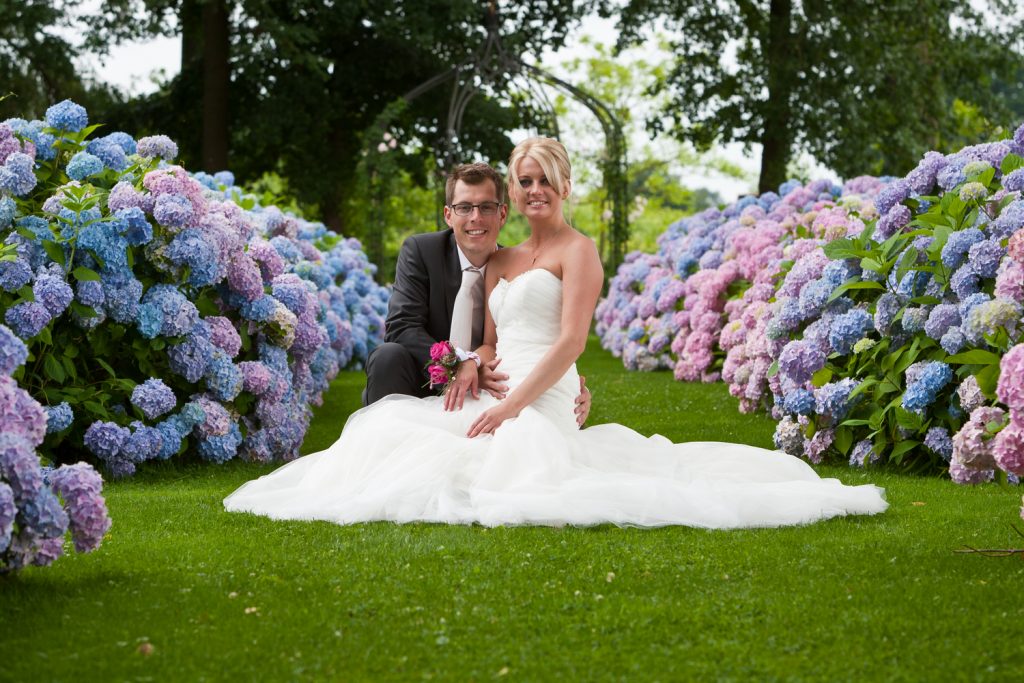 Bruidsfotografie Berry en Saskia in tuin Kasteel Groot Buggenum tussen de bloemen