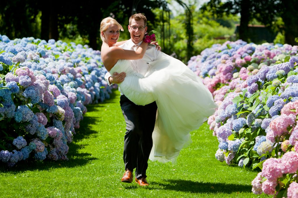 Bruidsfotografie Berry en Saskia in tuin Kasteel Groot Buggenum tussen de bloemen