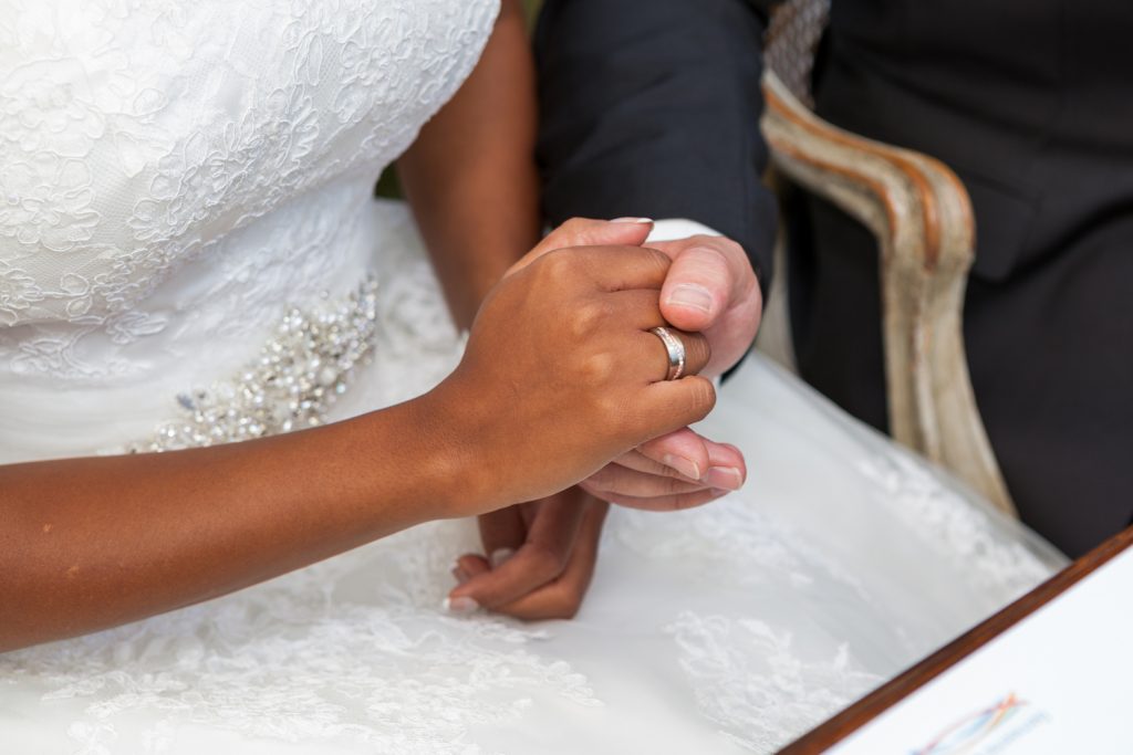 Bruidsreportage Ali en Tamara ceremonie handen vasthouden na ringen uitwisselen Kasteel Groot Buggenum