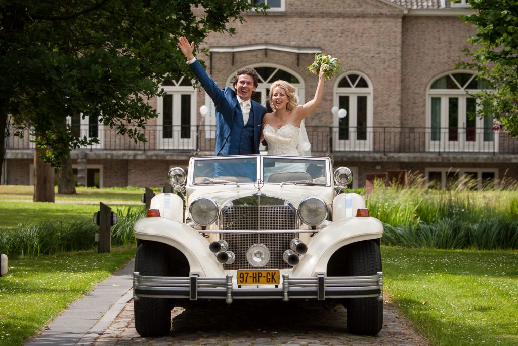 Bruidsreportage Willem en Robin met de auto voor de feestlocatie Chateau de Raay
