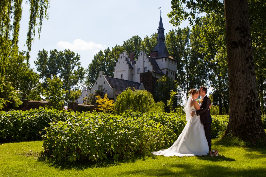 Bruidsreportage William en Valerie in de tuin met op de achtergrond Kasteel Groot Buggenum