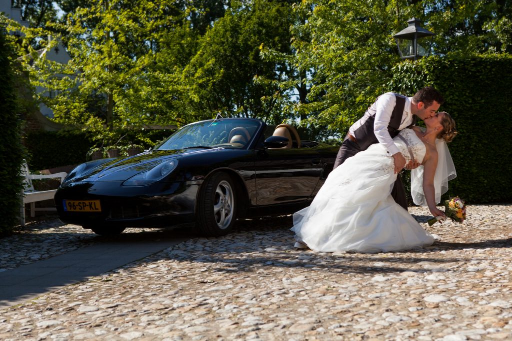 Bruidsreportage William en Valerie op een plein samen met de auto bij Kasteel Groot Buggenum