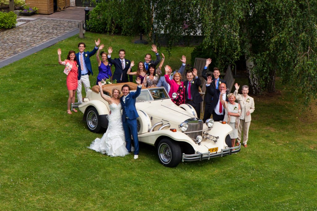 Bruidsreportage Willem en Robin hoogtefoto daggasten op grasveld met de auto bij Chateau de Raay